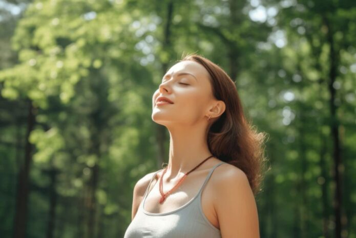 A woman is receiving drip hydration iv therapy while meditating in the woods.