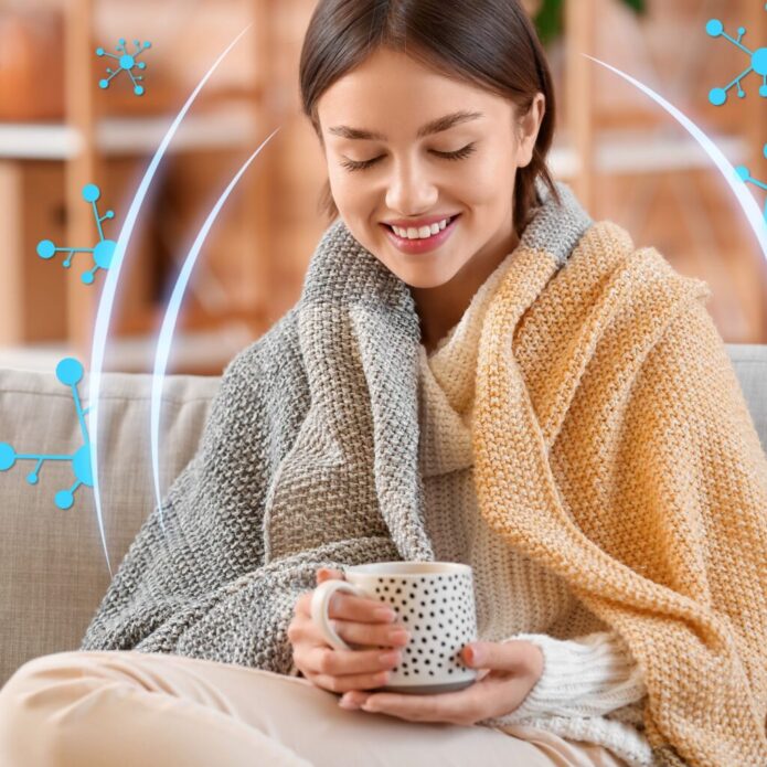 A woman is sitting on a couch with a cup of coffee.