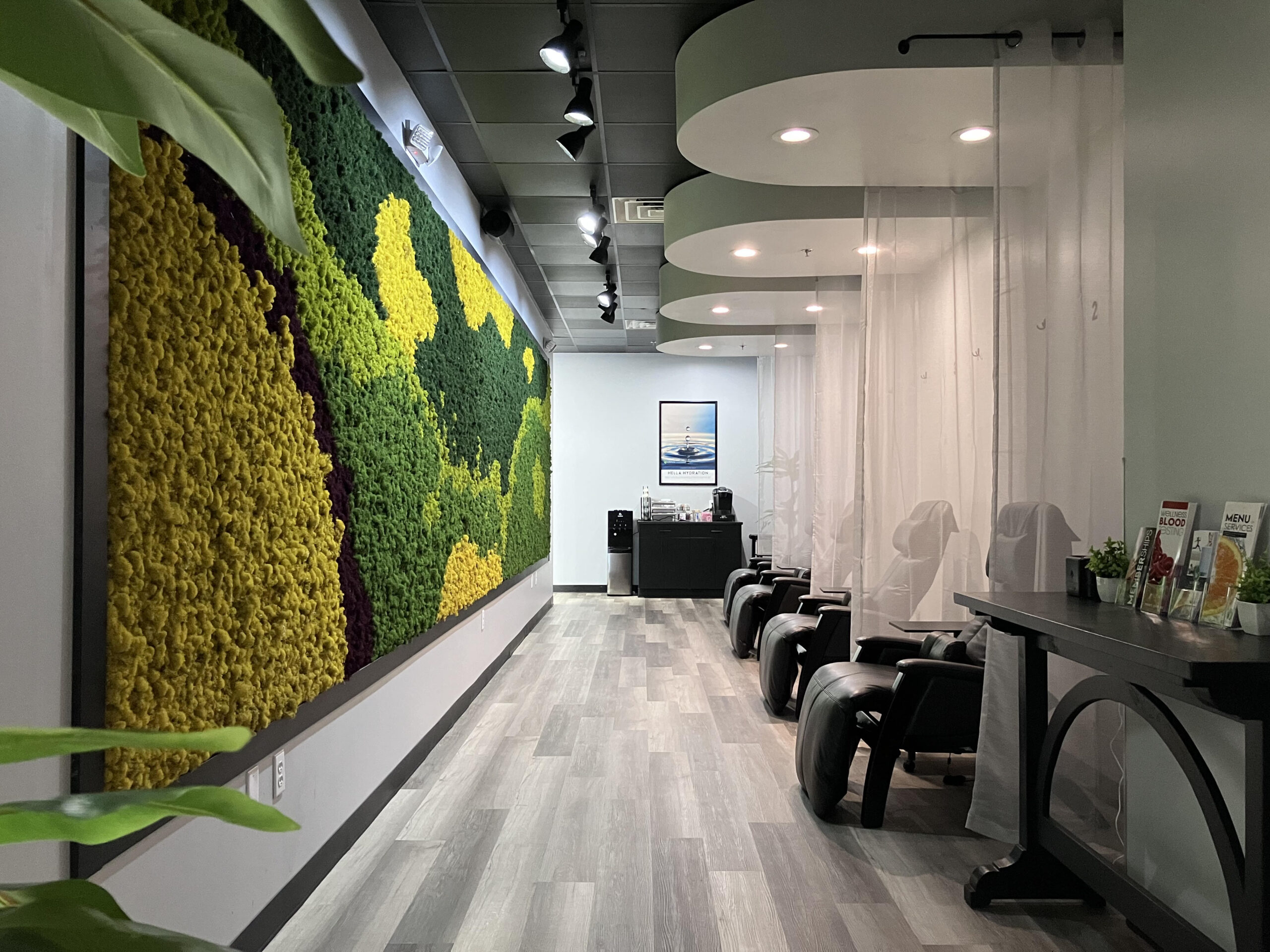 A salon offering blood testing services with a wall covered in plants and moss.